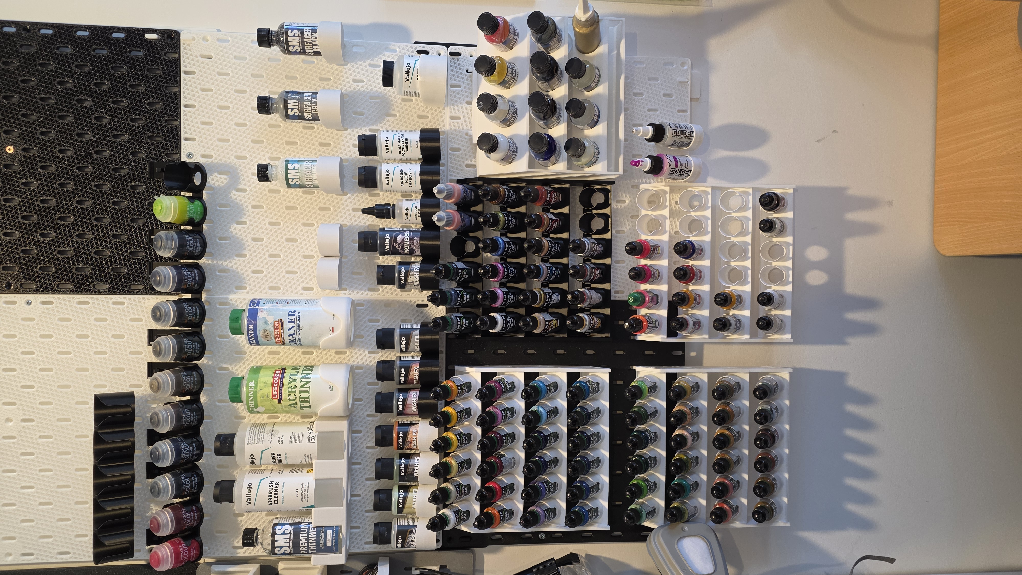 Upgraded studio paint wall with expanded racks, paint bottles and preparation supplies